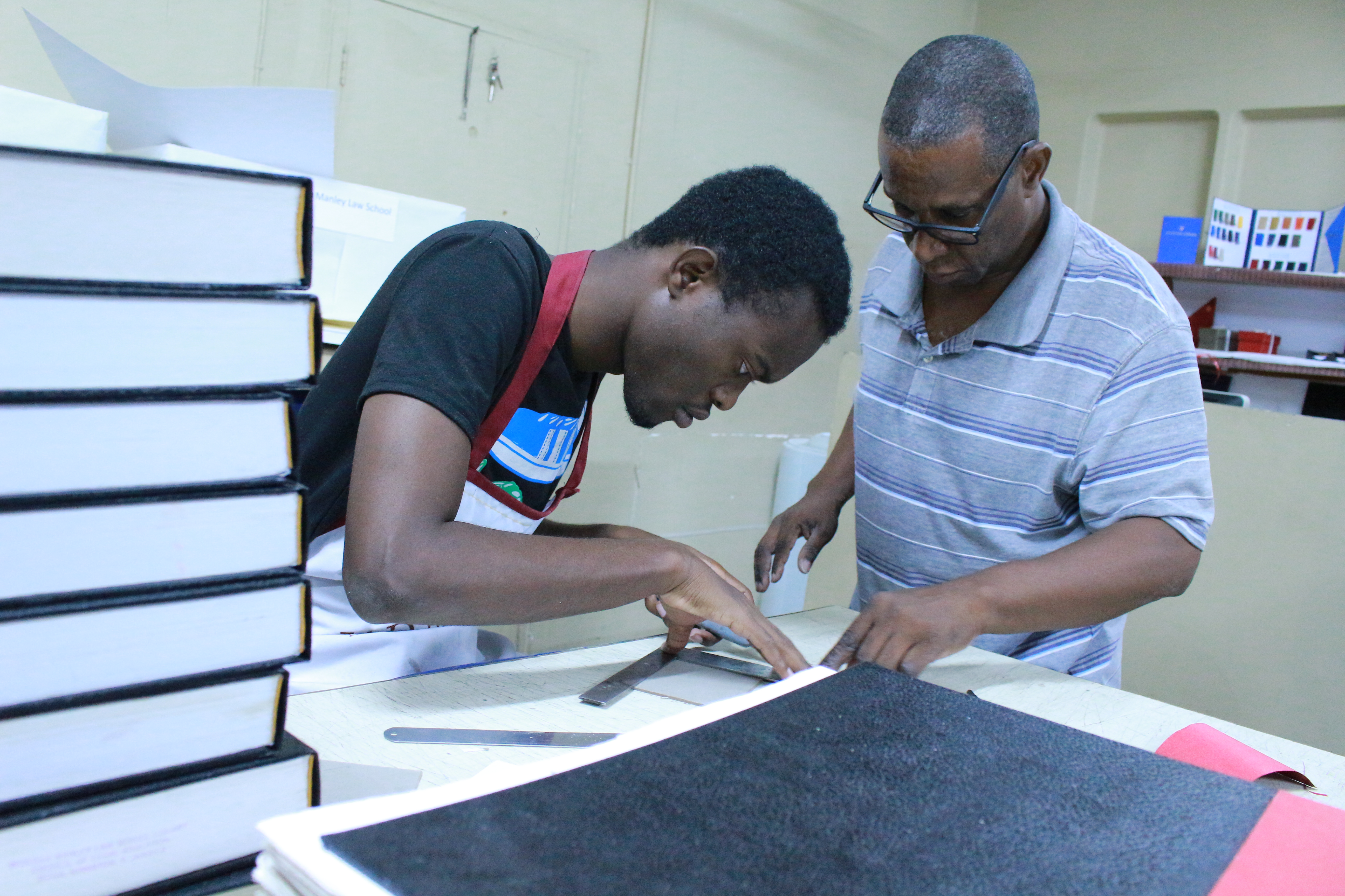 Desmond Senior (right) trains Travis Hines how to do binding.